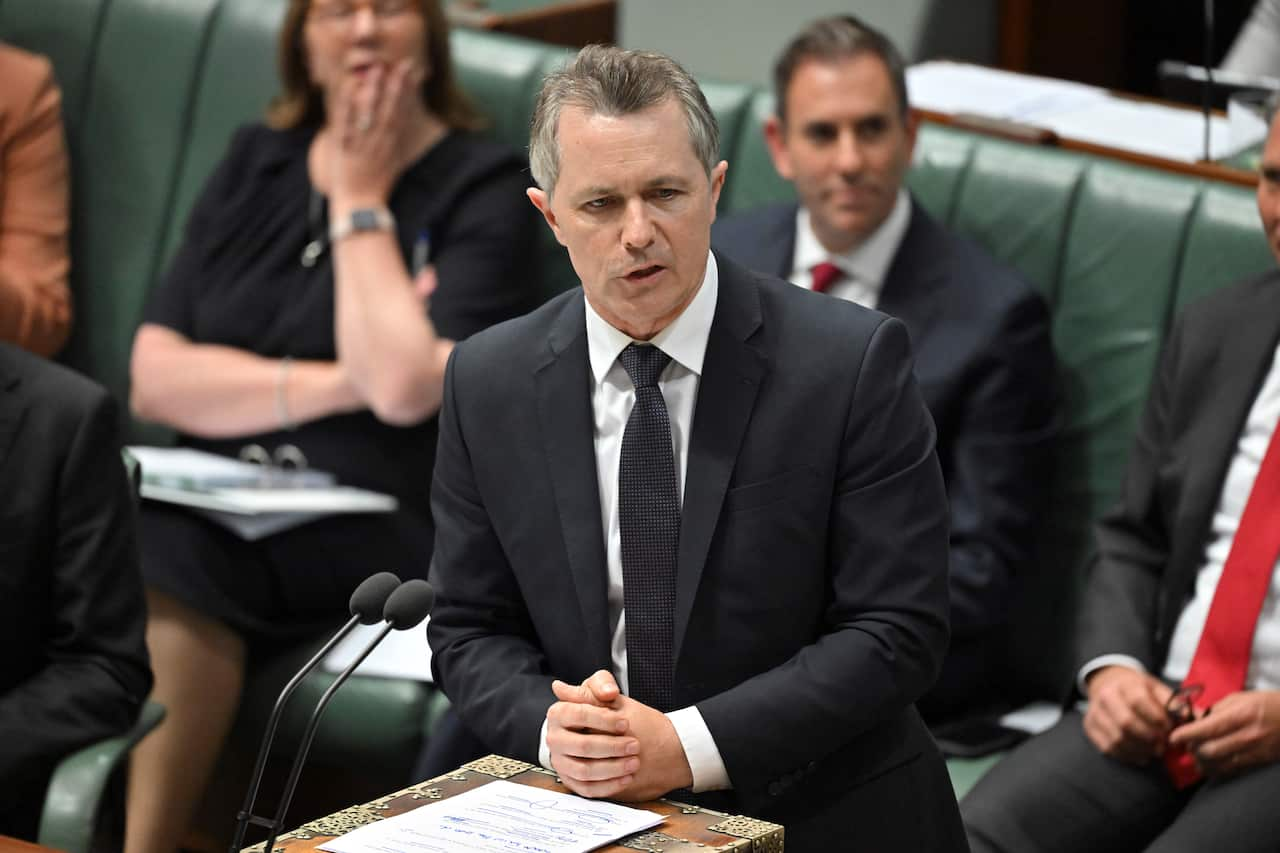 A man in a suit standing and talking in federal parliament