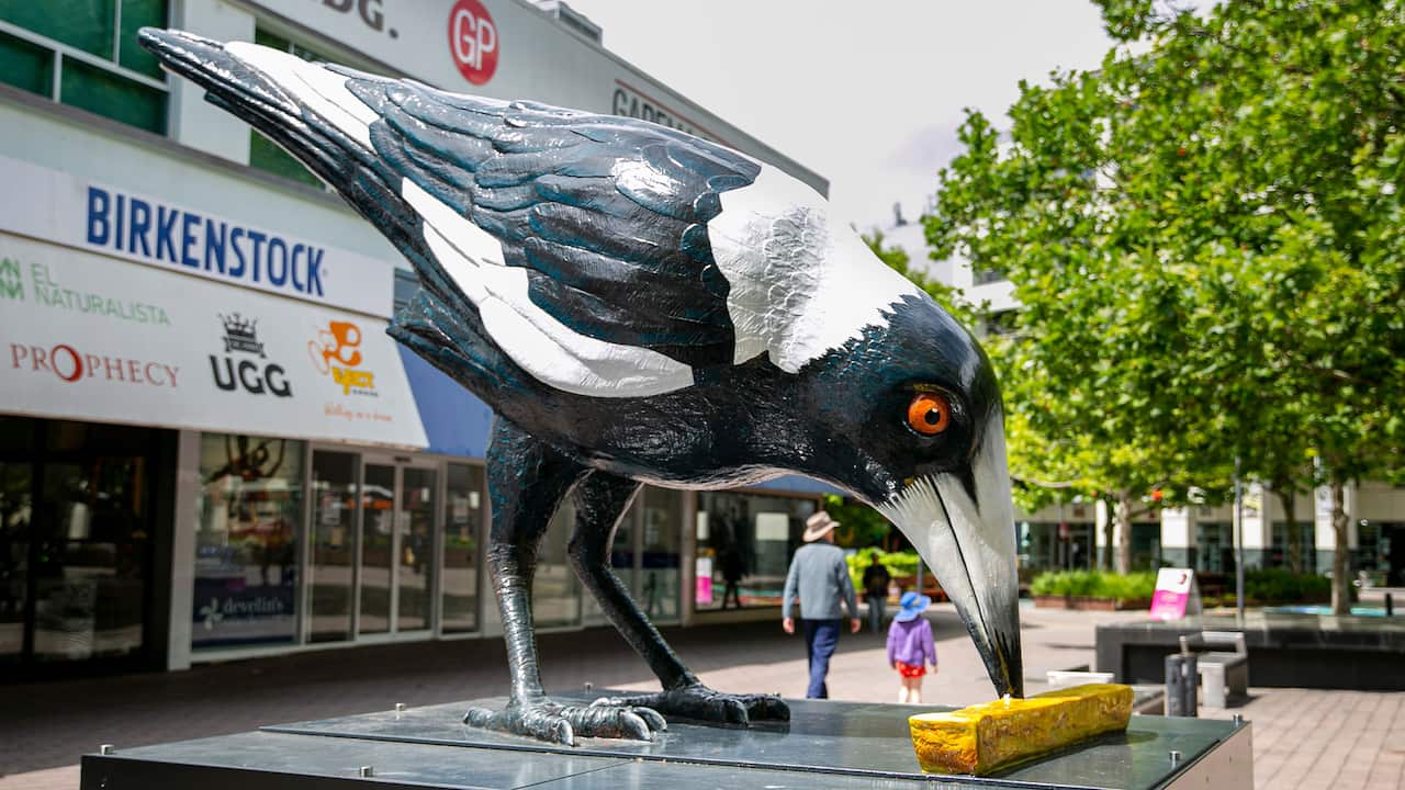 A huge sculpture of a magpie eating a potato chip.