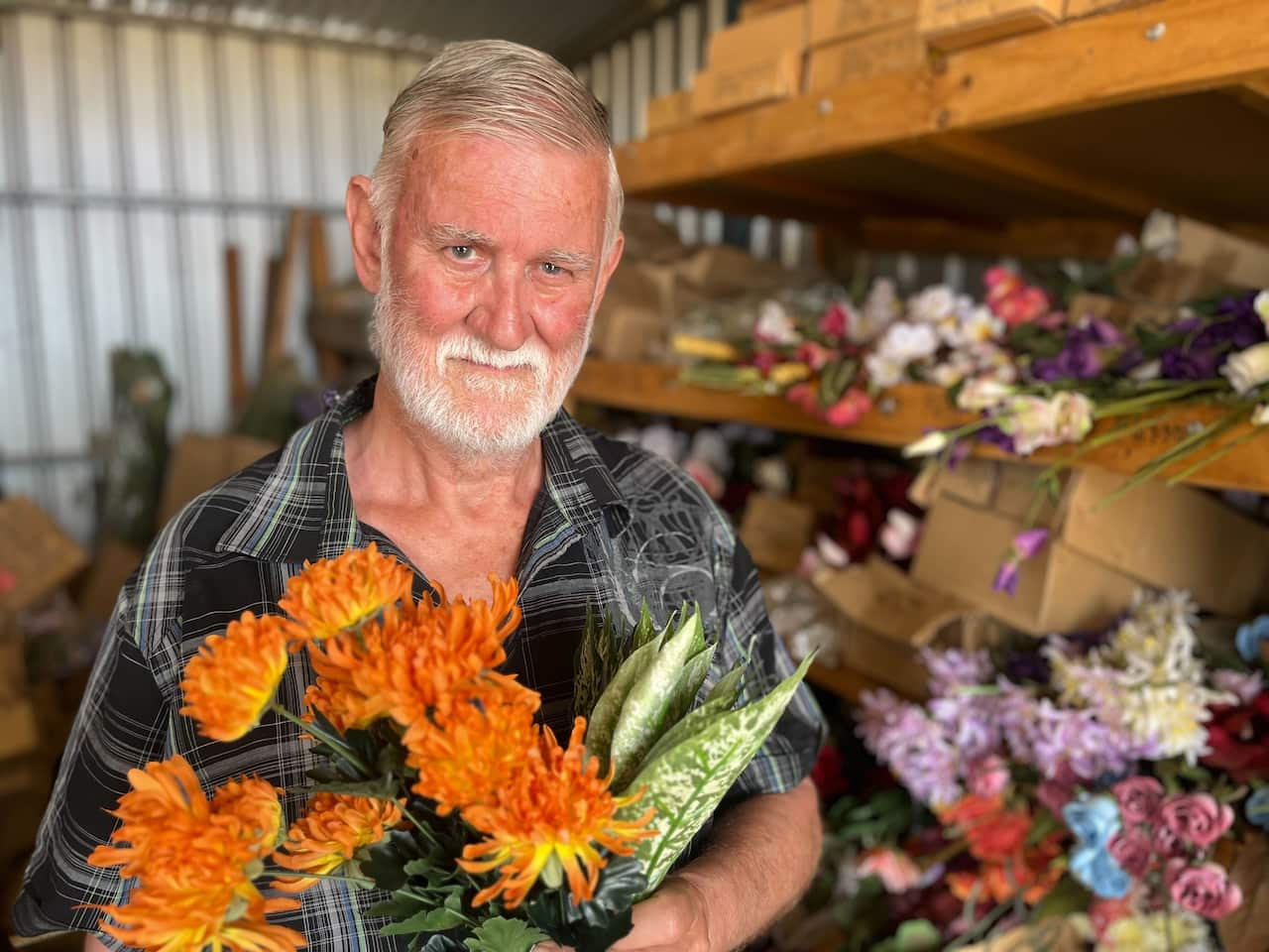 A man holding a bunch of artificial flowers