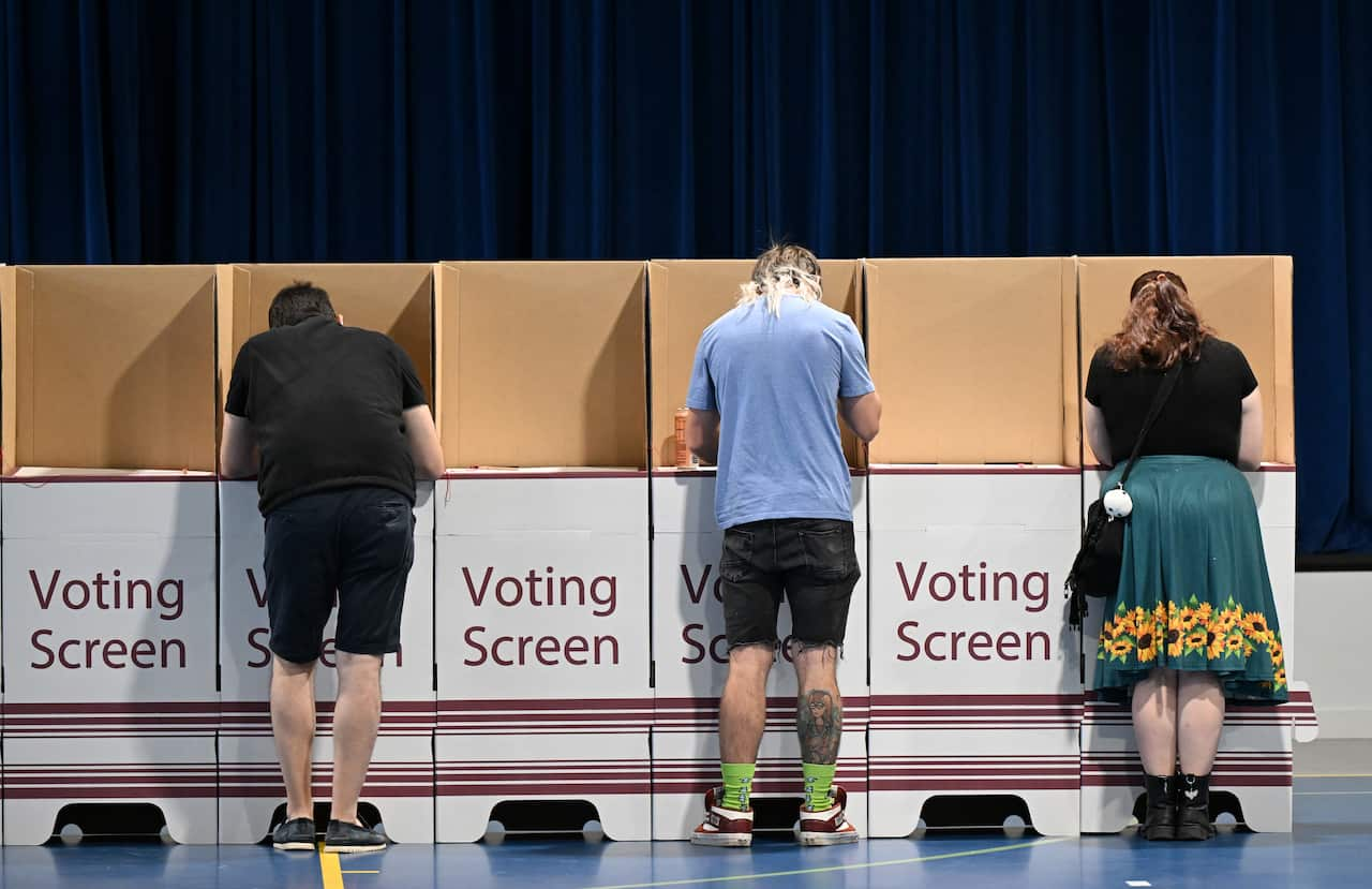 People vote in polling booths at a polling station