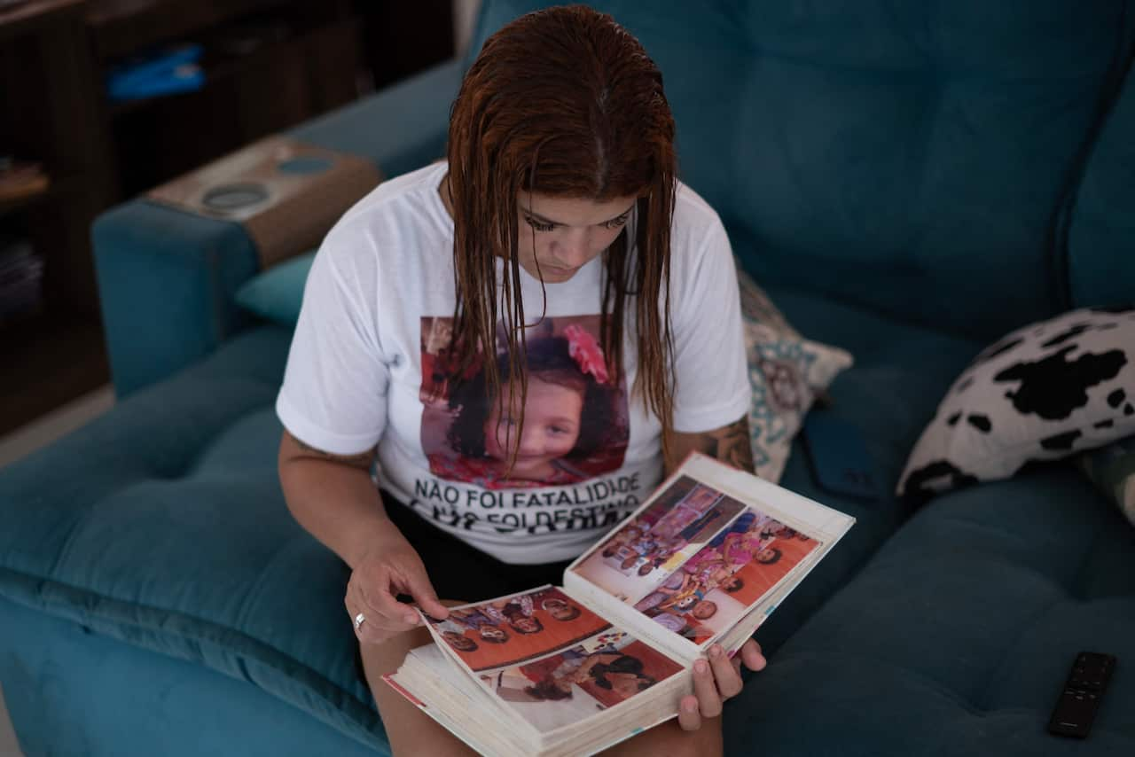 A woman sitting on a couch looking in a photo album