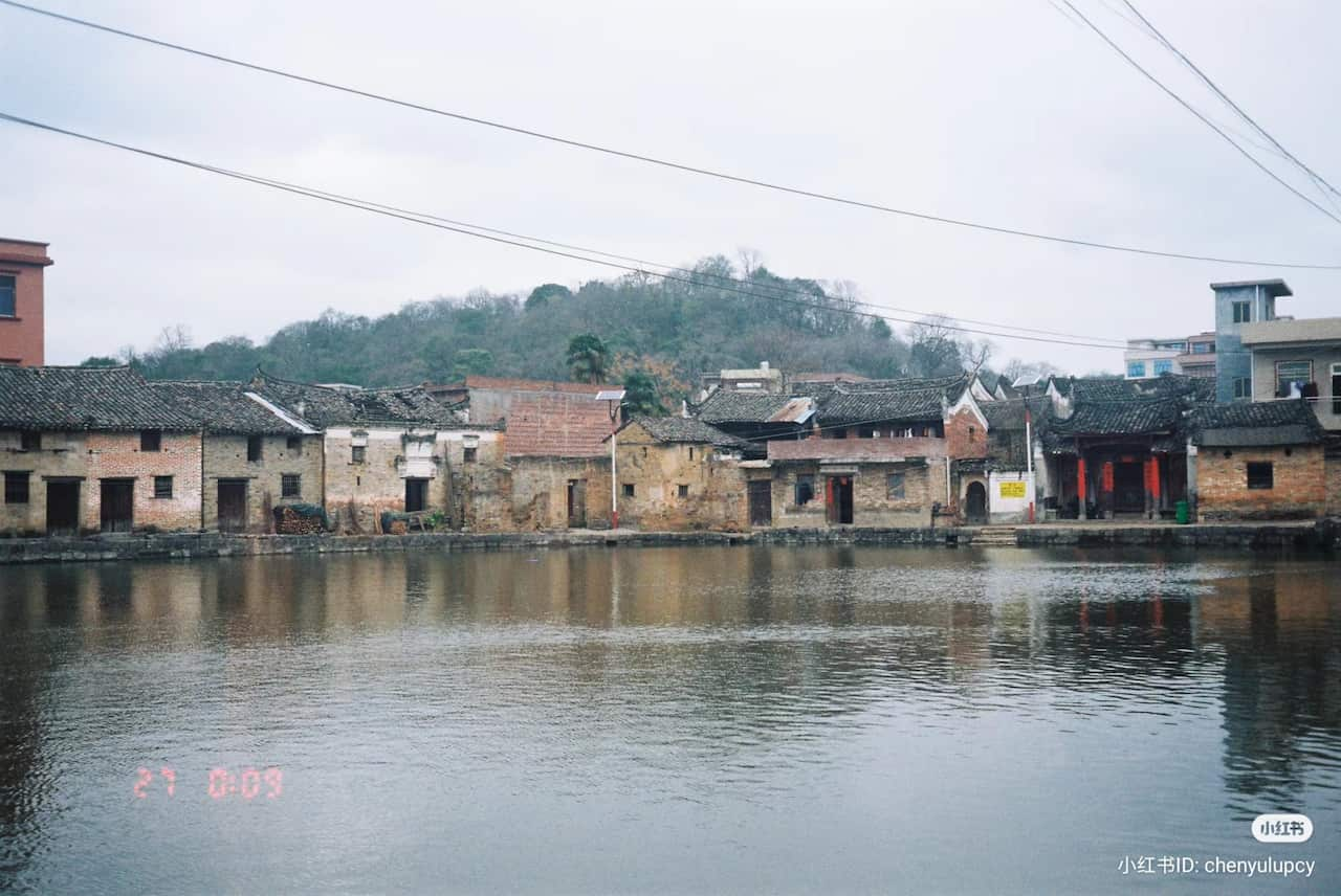 Brick village houses behind a lake 