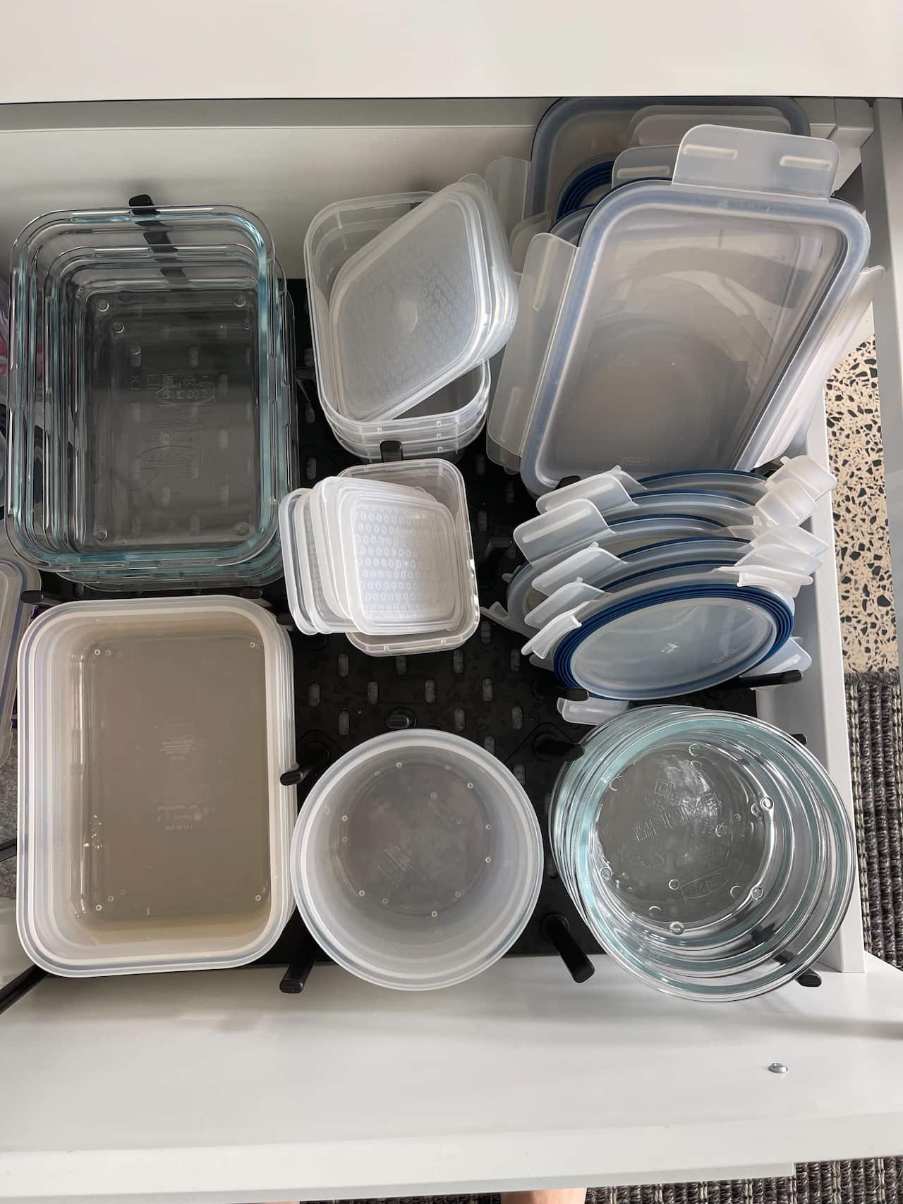 A drawer with neatly staked containers and lids