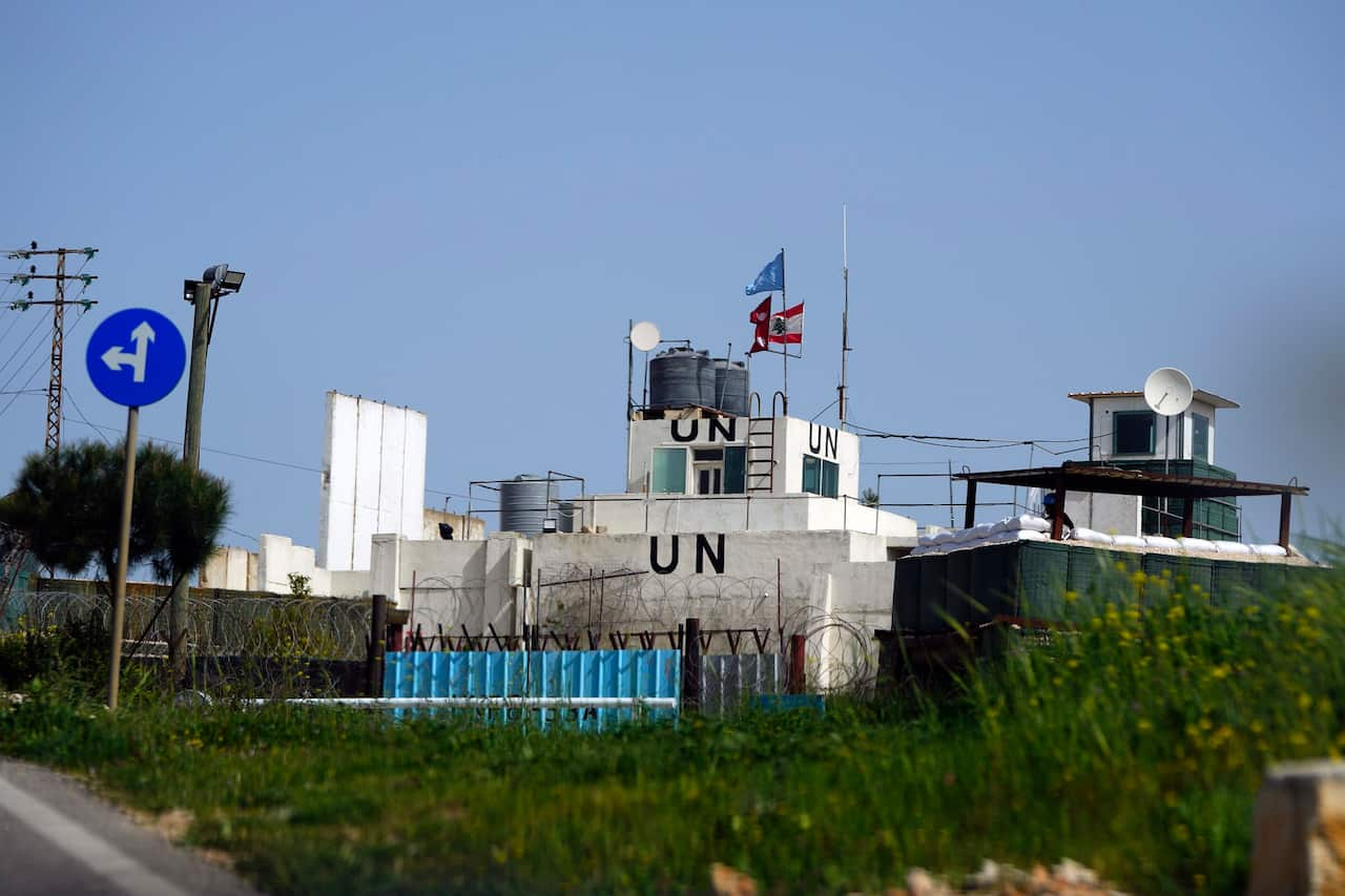 A white double-storey building with two flags and the letters 'UN' displayed on it.