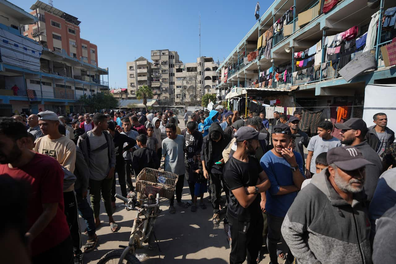 A large crowd of Palestinian people queueing up to receive aid.