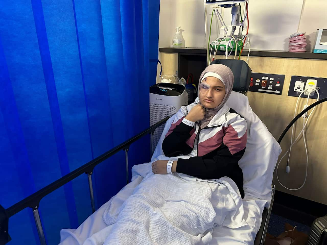 A woman sits in a hospital bed