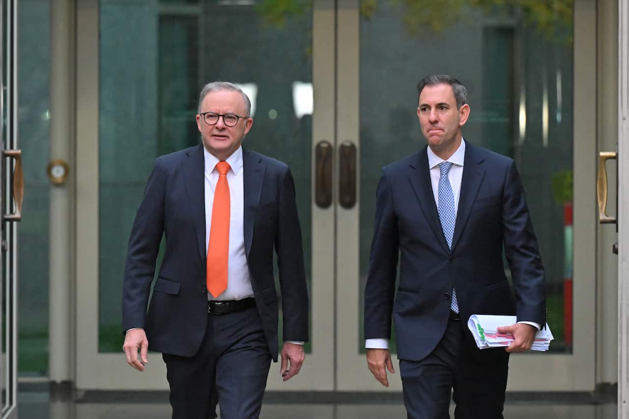 Two men wearing suits are walking.