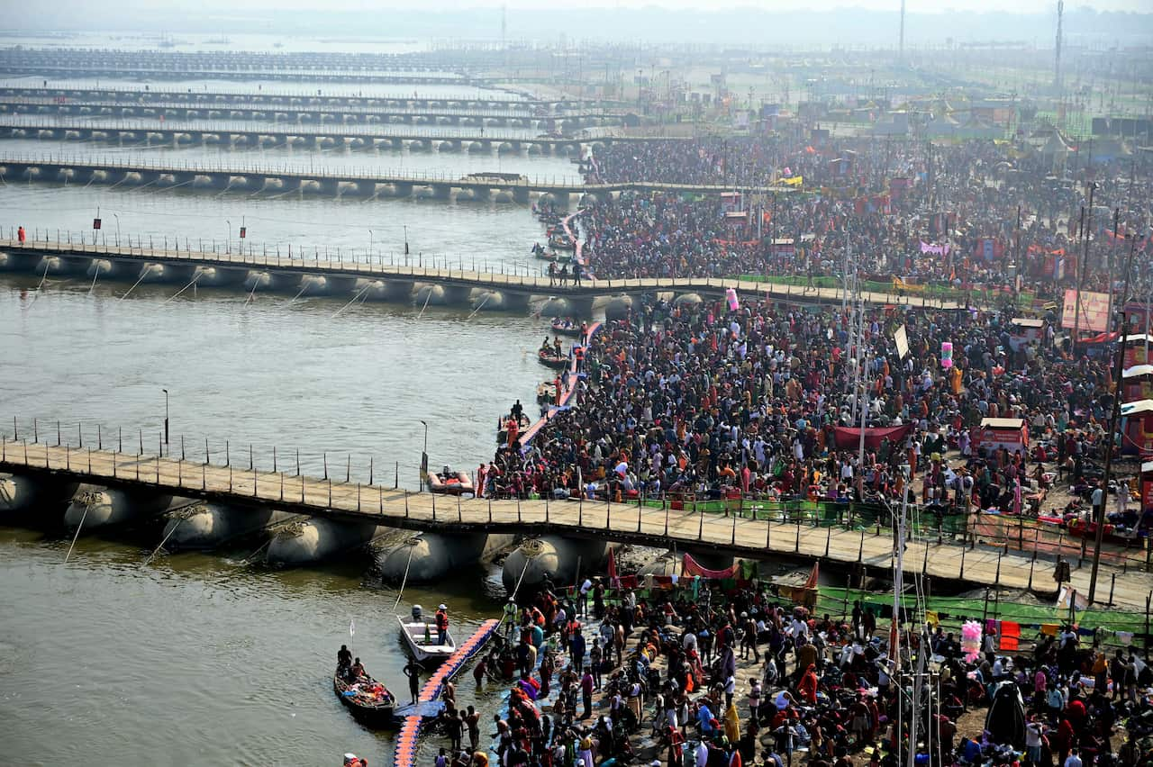 A large crowd gathered in front of a river, with narrow bridges crowded on either side.