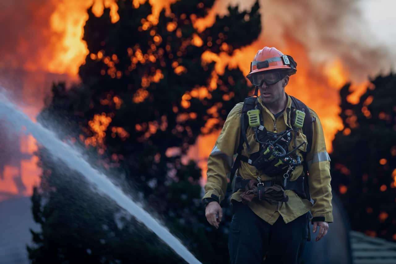 A firefighter in front of a blaze