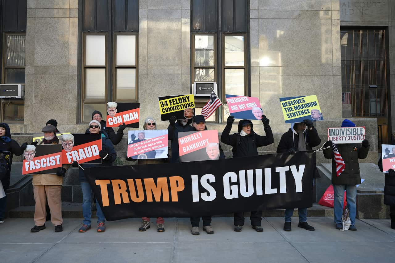 A group of protesters holding up signs and a banner that reads "Trump is Guilty".