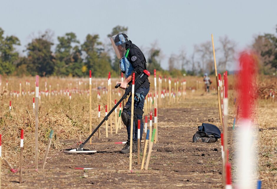 A Halo Trust deminer uses a metal detector to search for threats