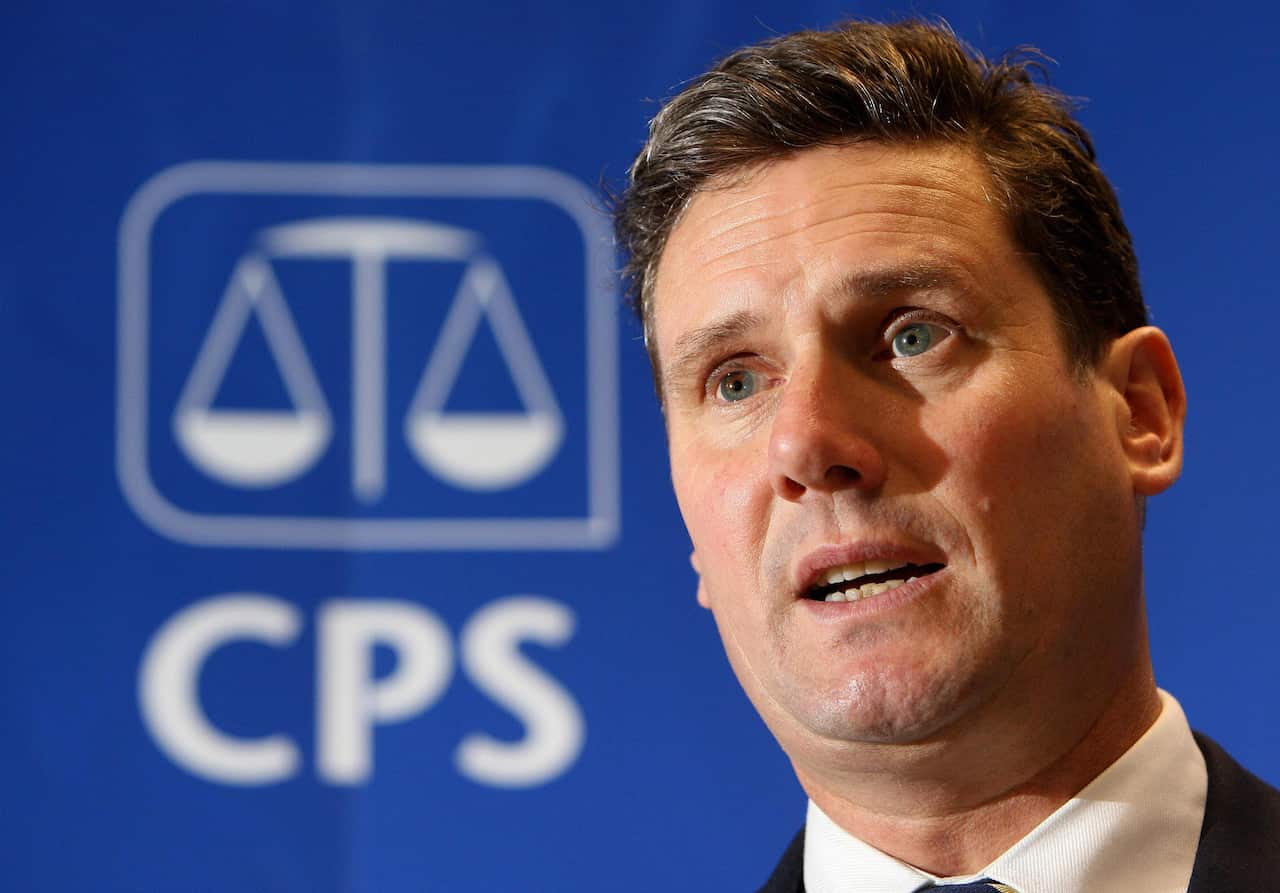 Keir Starmer standing in front of a blue media wall with the CPS logo on it