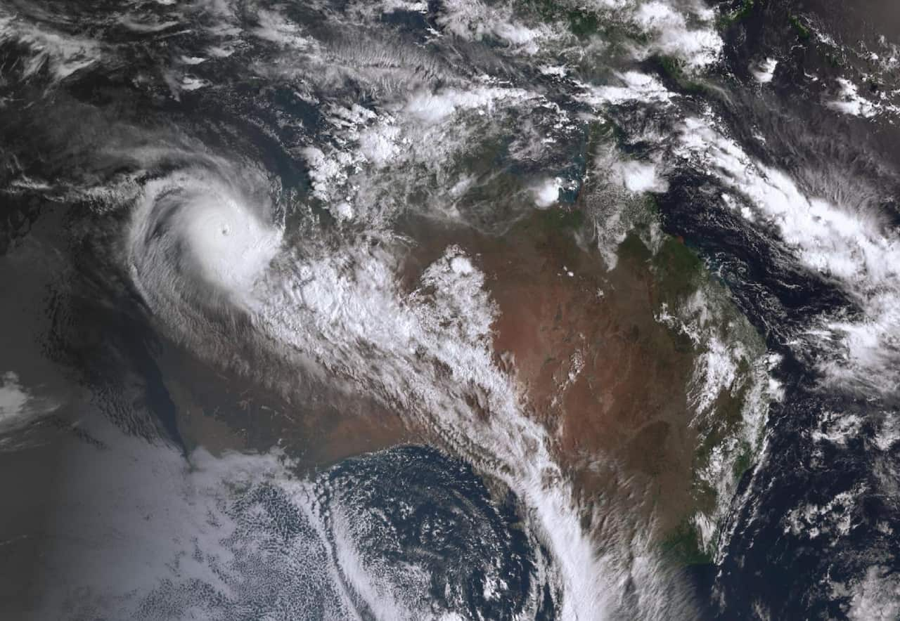 A satellite image of a cyclone shows swirling clouds forming a tornado-like pattern.