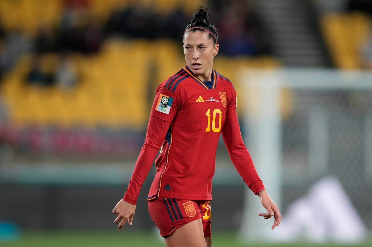 A female football player in red T-shirt and shorts during a match 