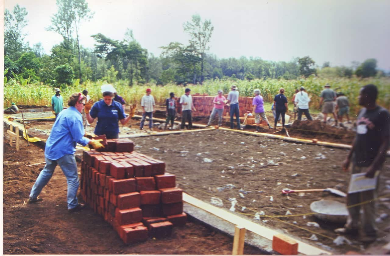 A group of people laying the foundations for a building around 2001.