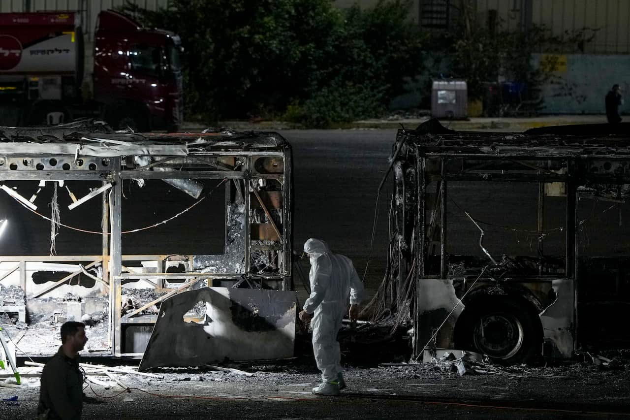 Police inspect the scene of a bus explosion. 