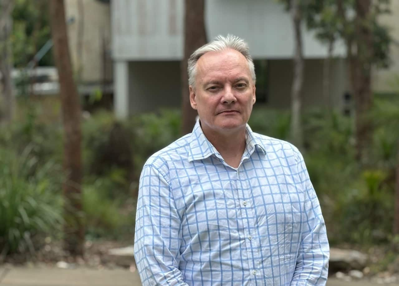 A man in a light blue checkered shirt.